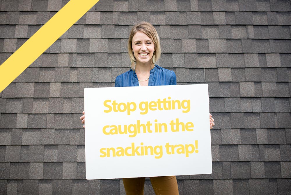 Jessica holding sign that says "stop getting caught in the snacking trap!"